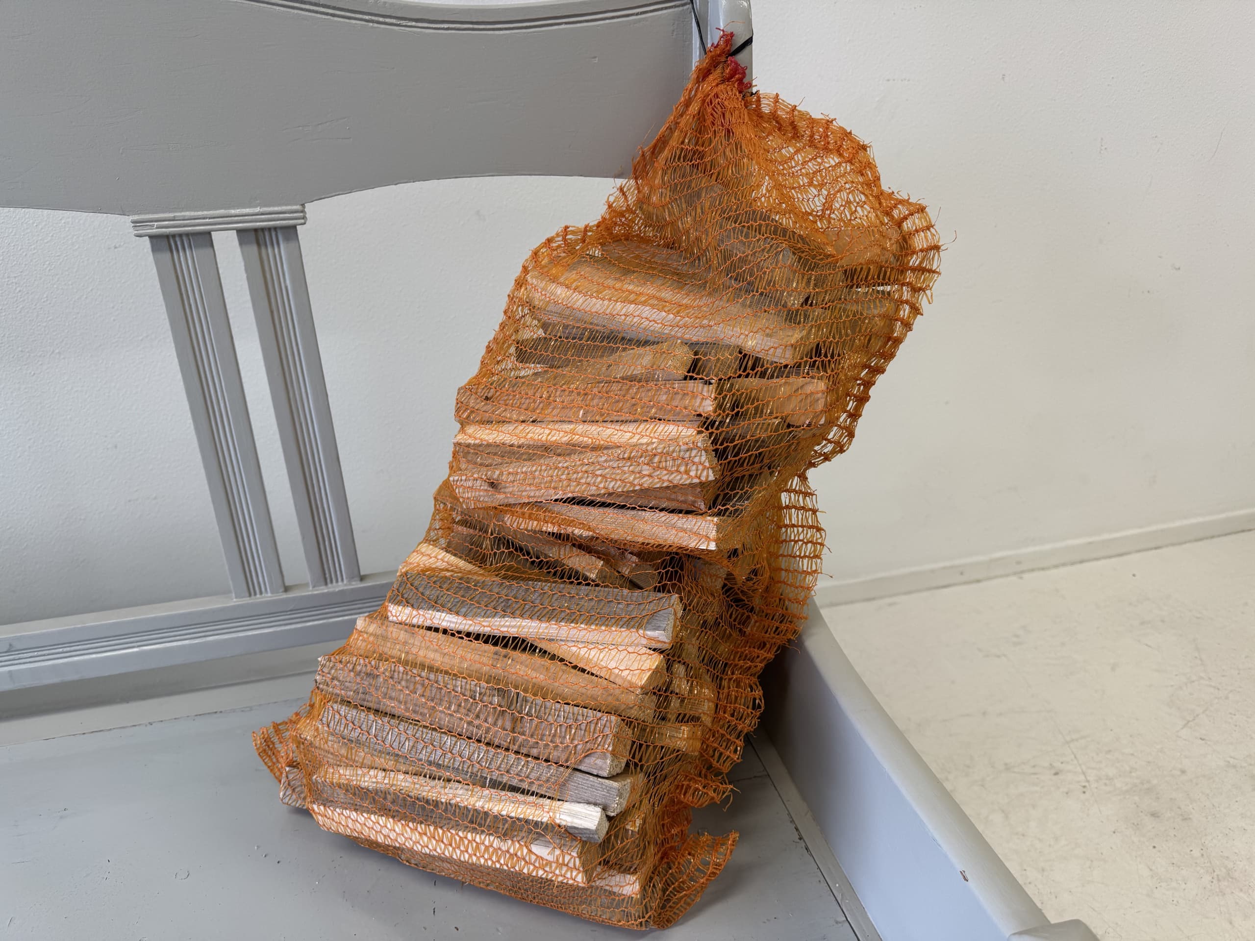 Netzak met gekloofd, droog hout op een grijze houten bank