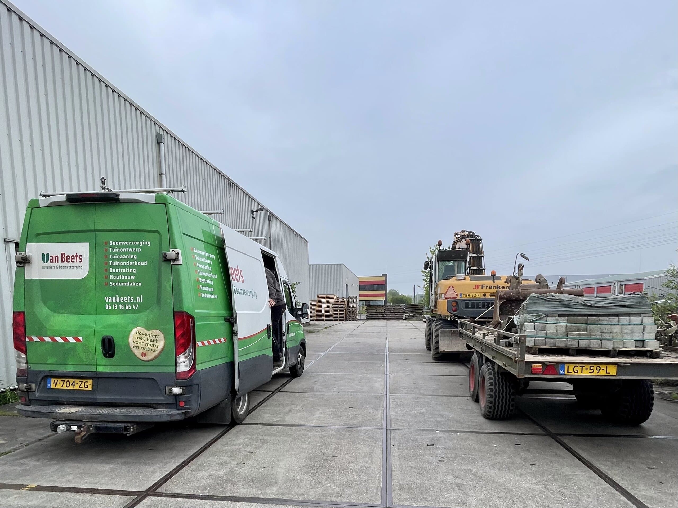 Bus van Van Beets met een aanhanger vol trottoirbanden voor de nieuwe verharding