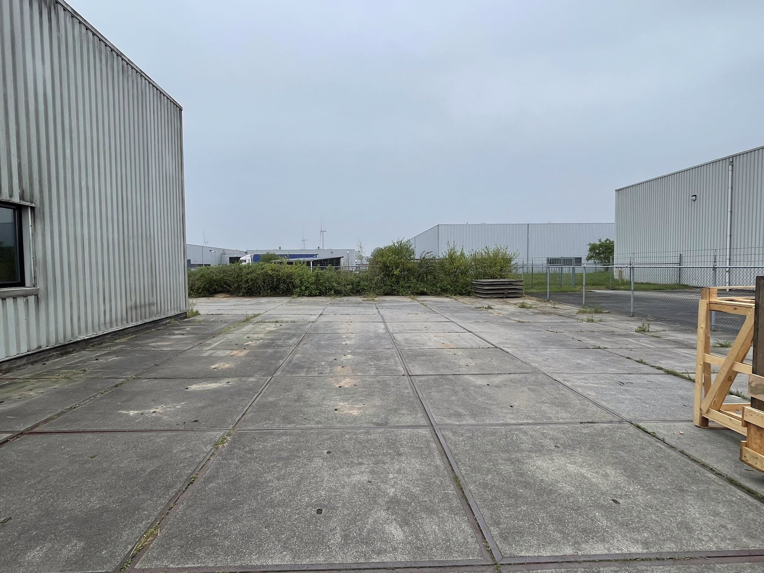 Graafmachine op het terrein, klaar om de betonplaten los te breken