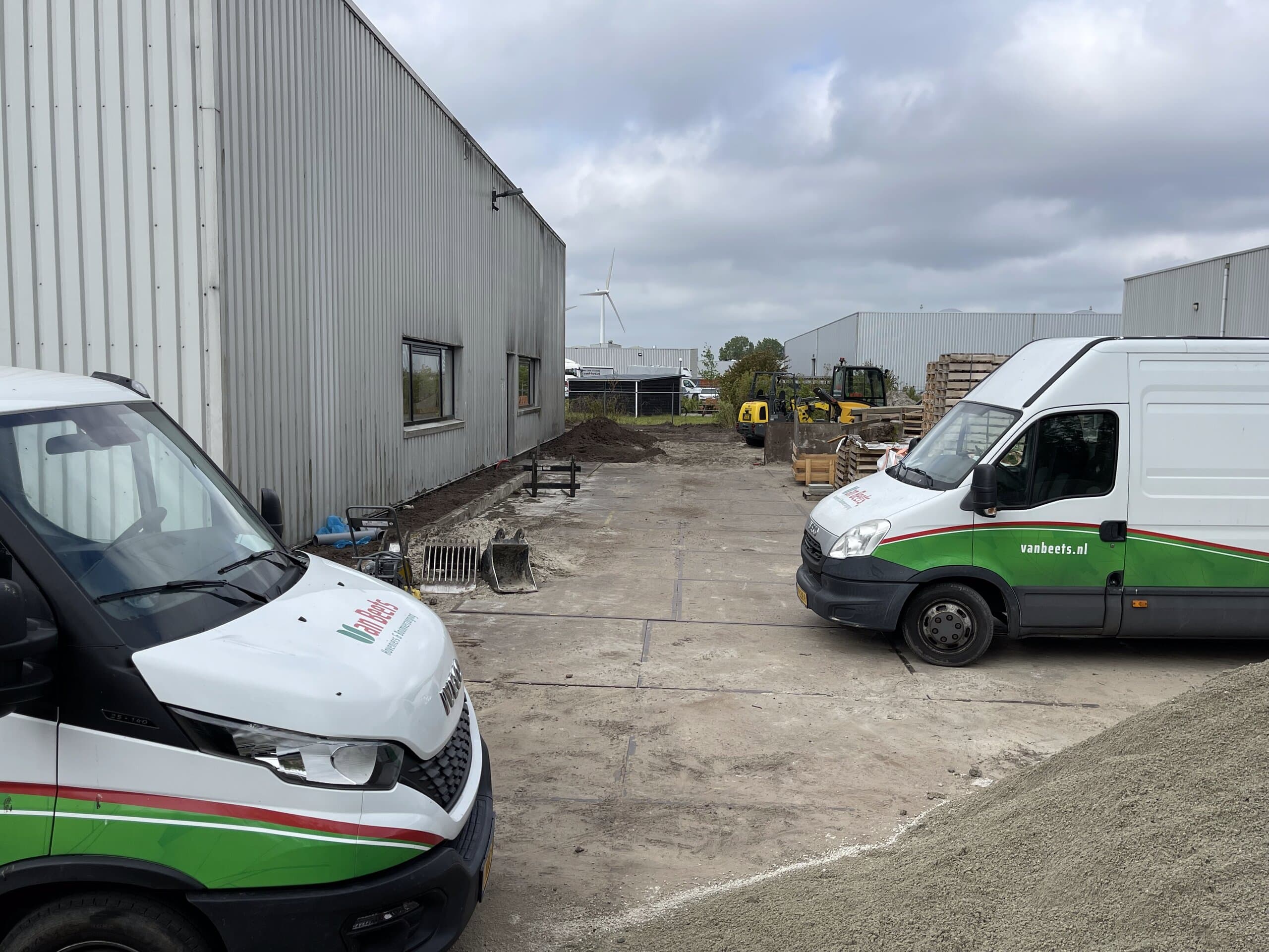 Bussen van Van Beets op het terrein terwijl de teelaarde wordt uitgespreid over het afgegraven zand