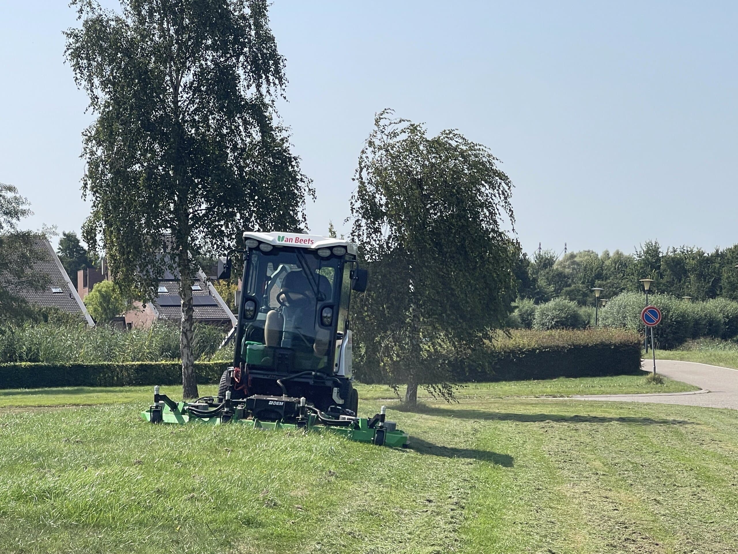 Maaimachine van Van Beets maait een groot gazon in een woonwijk