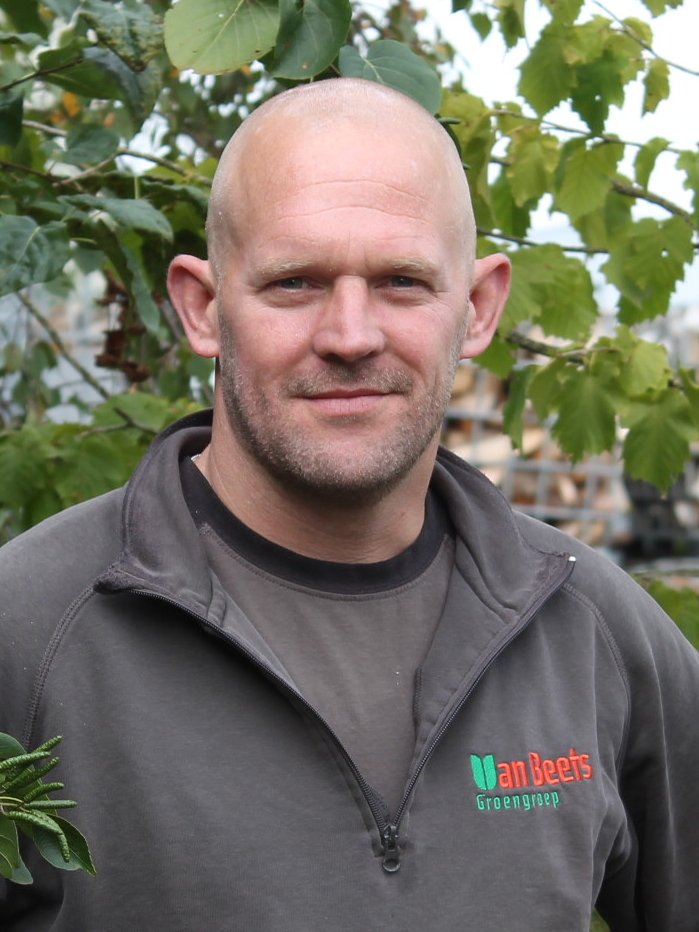 Hein Sinnema, werkvoorbereider bij Van Beets, buiten voor het groen in een Van Beets-trui
