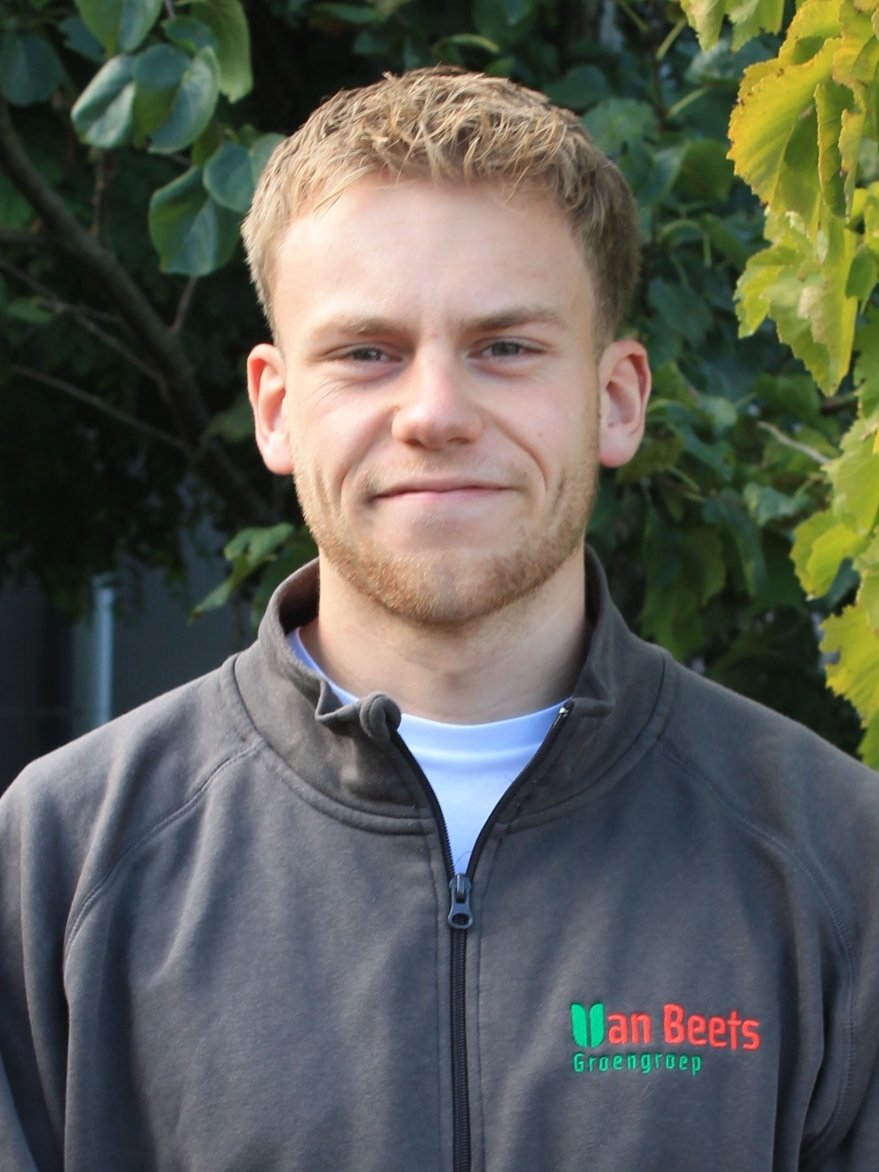Niels van Beets, administratie bij Van Beets, buiten voor het groen in een Van Beets-trui