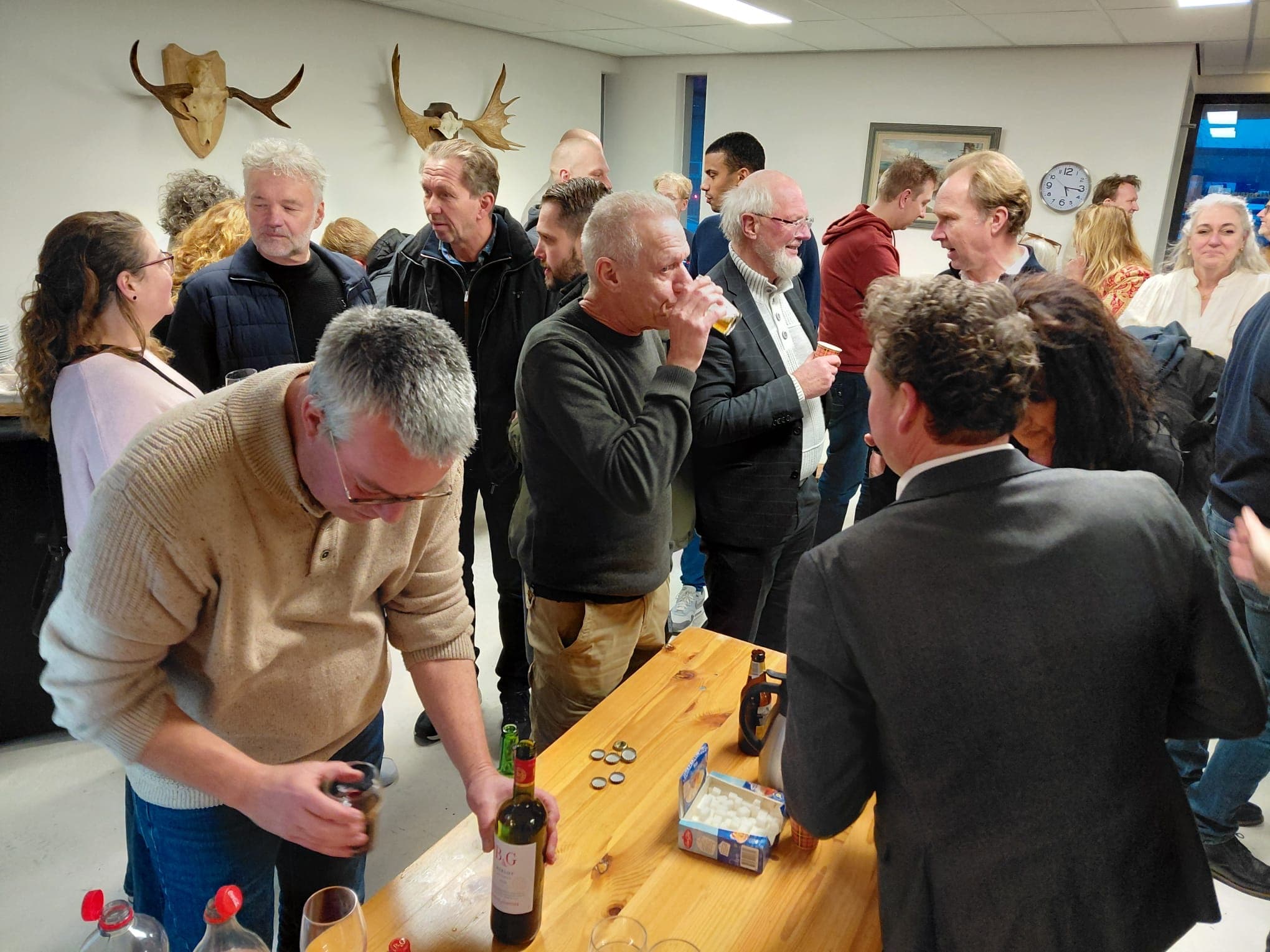 Ondernemers van De Hemrik in gesprek rond een statafel met drankjes tijdens de nieuwjaarsbijeenkomst bij Van Beets
