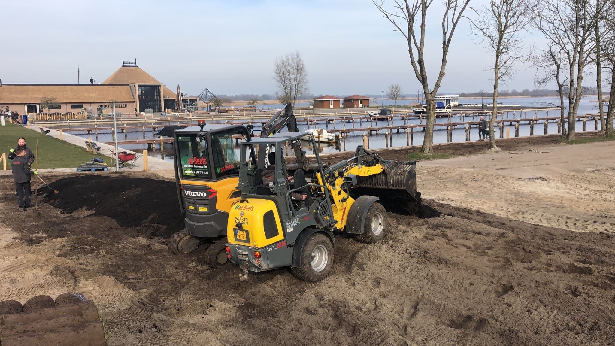 Graafmachine en shovel van Van Beets vlakken de teelaarde uit op het terrein bij de haven